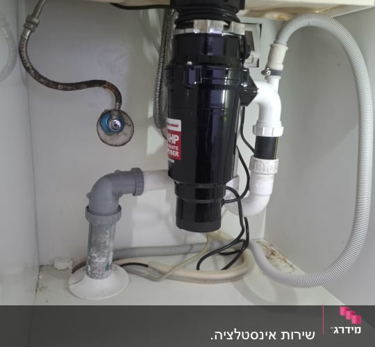 מתקן טוחן אשפה מתחת לכיור במטבח